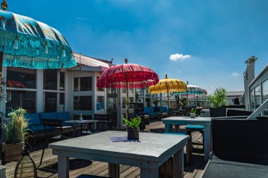 IJmuiden, Hollanda, 30 Mayıs 2021, güneşli bir günde bir sahil kulübünün terasında renkli Hint şemsiyeleri.