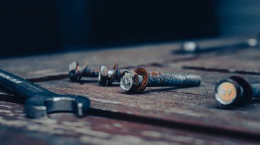 Ahşap bir masanın üzerinde kısmen paslanmış bir cıvata görüntüsü.