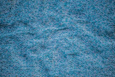 Örülmüş kumaş, soyut mavi doku arka plan, ürünün üzerine katlar, kalın elbiseler süveter.