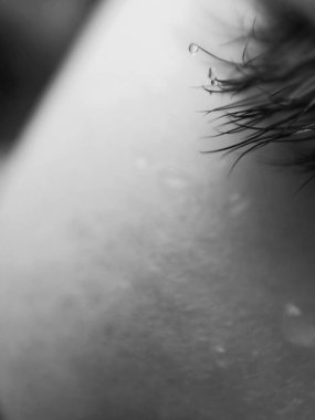 Kirpiklere bir damla su, yakın çekim, soyut görüntü, bulanık olmayan fotoğraf, kirpiklerdeki gözyaşları.