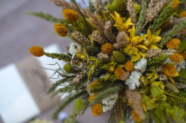 Bir buket yabani çiçekte alyans, düğün buketi, geline bir hediye.