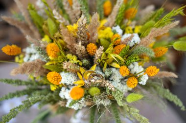 Bir buket yabani çiçekte alyans, düğün buketi, geline bir hediye.