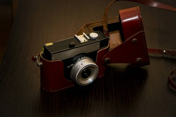 photographic equipment, retro camera on a brown background, vintage camera, leather case, brown antique