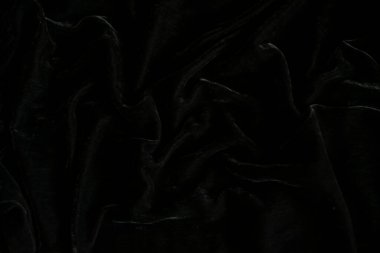 Arka plan olarak siyah kadife kumaşın üst görüntüsü, kadife arka plan. Kadife siyah. Güzel kumaş. Soyut arkaplan, seçici odaklanma, yumuşak bulanıklık.