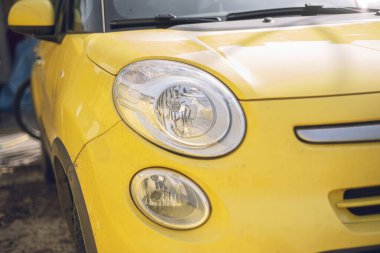 Çamurlu sarı kapüşon parçası, sarı kirli araba parçası, yakın plan ve seçici odak, arka plan olarak kullanılacak güzel doku ve renk..