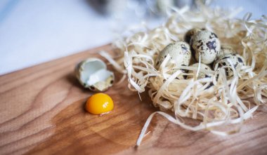 Tahtada taze bıldırcın yumurtaları, lezzetli bir Paskalya tatili için bıldırcın yumurtaları mutfak tahtasına çiğ konmuş bıldırcın yumurtası, çiğ yumurta sarısı ve yumurta beyazı.