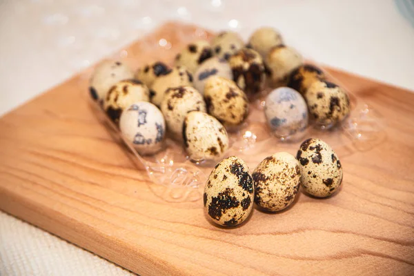 fresh quail eggs in a plastic box on a wooden board, quail eggs for a delicious Easter holiday in a tray, preparation for Easter, healthy dietary food, diet