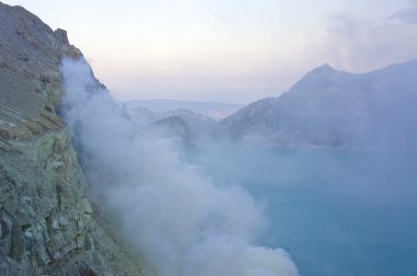 Ijen'de volkan Doğu Java dünyanın en büyük asidik volkanik krater Kawah Ijen'de, denilen kükürt sabah duman dışarı spewing Gölü, içerir. Güneş siste gizlenmiş.