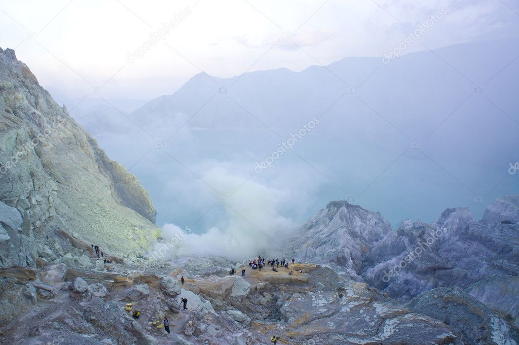 Ijen volcano in East Java contains the world's largest acidic volcanic crater lake, called Kawah Ijen, spewing out sulphur smoke in the morning. Sun is hidden in mist.