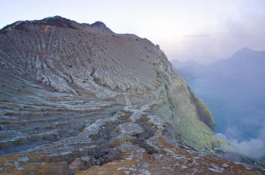 Ijen'de volkan Doğu Java dünyanın en büyük asidik volkanik krater Kawah Ijen'de, denilen kükürt sabah duman dışarı spewing Gölü, içerir. Güneş siste gizlenmiş.