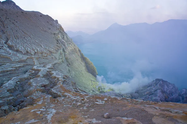 Ijen'de volkan Doğu Java dünyanın en büyük asidik volkanik krater Kawah Ijen'de, denilen kükürt sabah duman dışarı spewing Gölü, içerir. Güneş siste gizlenmiş.
