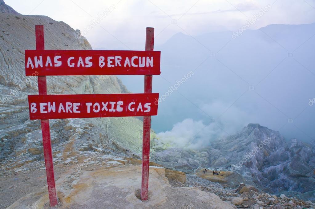Caution to beware toxic gas at Kawah Ijen volcano. Sun is hidden in mist.