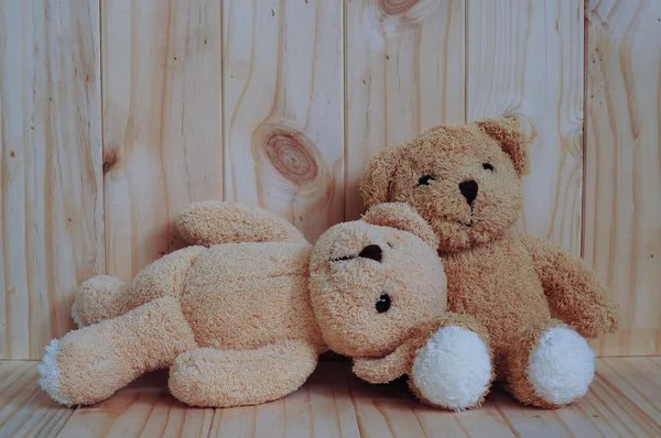 Due orsacchiotti seduti insieme su uno sfondo di legno. Abbracciati. Concetto di amicizia. Concetto d'amore. Biglietto d'auguri su legno . Foto Stock