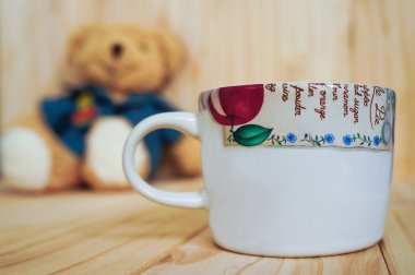 Oyuncak ayı ve ahşap arka plan ile bir fincan kahve. Vintage tarzı.