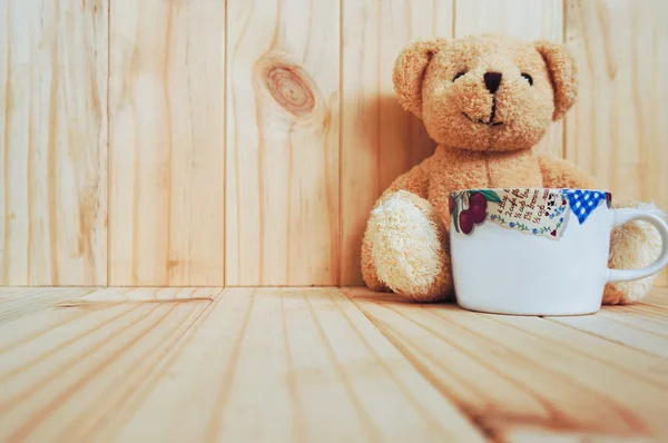 Una tazza di caffè con orsacchiotto e sfondo in legno. stile vintage . — Foto Stock