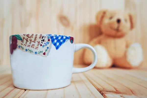 Una tazza di caffè con orsacchiotto e sfondo in legno. stile vintage . — Foto Stock