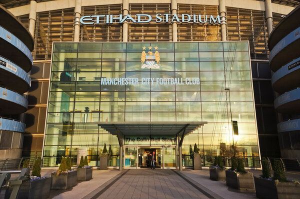 MANCHESTER, UK - Feb 10, 2014: The entrance of Etihad stadium in the evening light on February10, 2014 in Manchester, UK. Стадион Этихад является домом для футбольного клуба Манчестер Сити
.