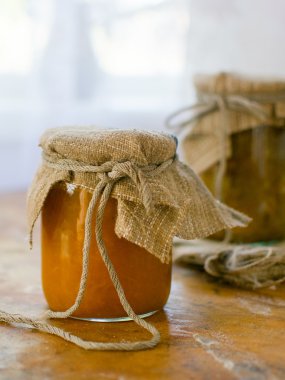 Ahşap bir masa üzerinde sarı reçelli kavanoz