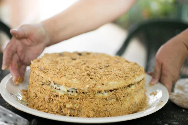 Menghiasi kue tradisional Rusia Napoleon dengan remah-remah kue — Stok Foto