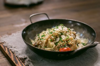 Somon ve dilimlenmiş fıstık, risotto, bir bıçak ve çatal holding erkek eller