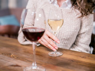 Kırmızı şarap bir bardak beyaz şarap bir arka plan üzerinde bir kadın elinde