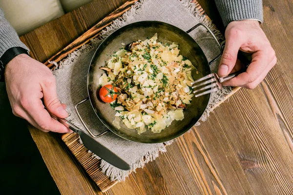 Risotto met zalm en gesneden pinda, mannelijke handen met een mes en een vork — Stockfoto