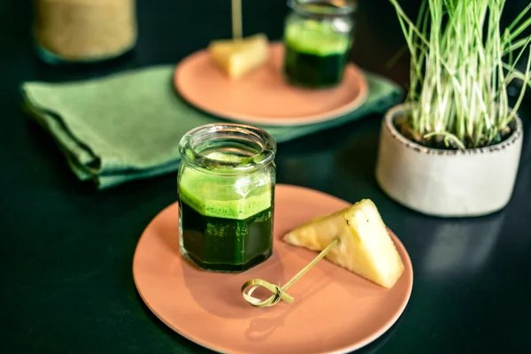 Buğday çimi suyu bir restoranda tabağa ananas parçası ile