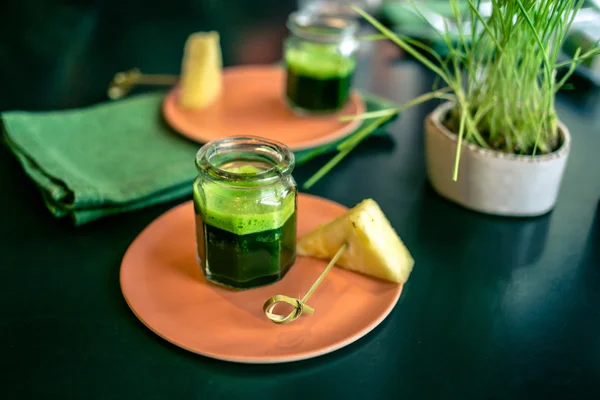 Wheatgrass juice with piece of pineapple on the plate in a restaurant — Stock Photo, Image