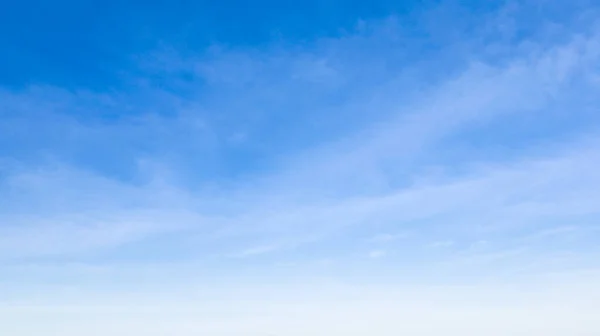 Yumuşak beyaz bulutlu açık mavi gökyüzü.
