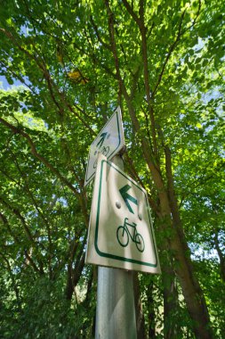 İşaretler iki yöne de bisikletçilerin yolunu gösteriyor. Yeşil yazılı beyaz tabela. Alman trafik levhası..