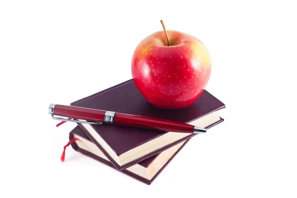 Apple ile kalem kitap yığını üzerinde