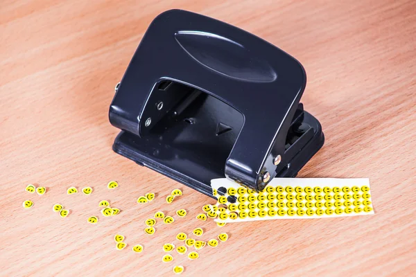 Hole punch and extruded paper smiles — Stock Photo, Image