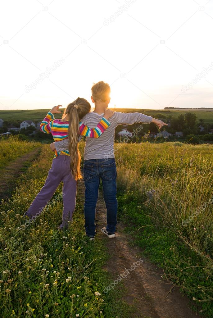 Boy and girl holding hands and walking along the road