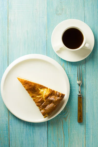 Un pedazo de pastel de requesón en un plato blanco — Foto de Stock