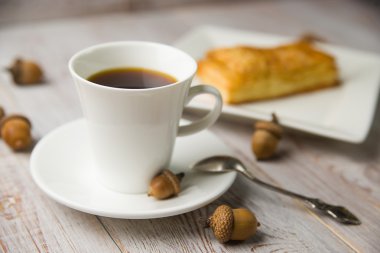 Fincan kahve, tatlı çörekler ve meşe palamutları