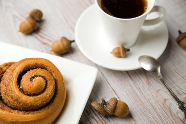 Fincan kahve, tatlı çörekler ve meşe palamutları