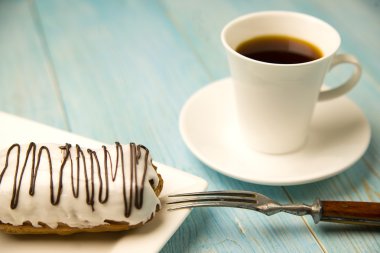 Fincan kahve ve tatlı buns üzerinde mavi üzerinde