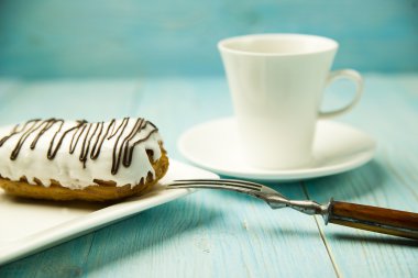 Fincan kahve ve tatlı buns üzerinde mavi üzerinde