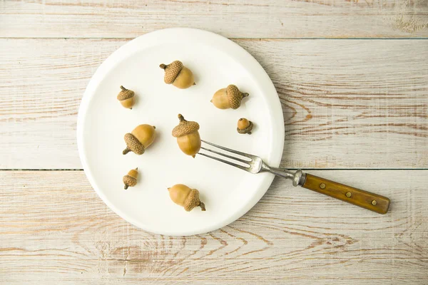 Acorns, plate and fork on the table — Stock Photo, Image