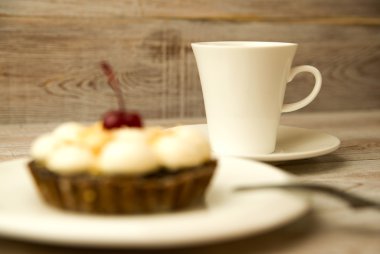 Kek kiraz ve masada bir fincan