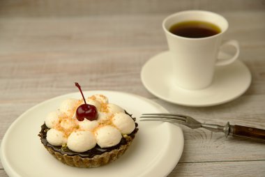 Kek kiraz ve masada bir fincan