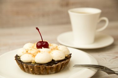 Kek kiraz ve masada bir fincan