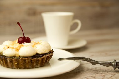 Kek kiraz ve masada bir fincan