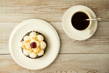 Kek kiraz ve masada bir fincan