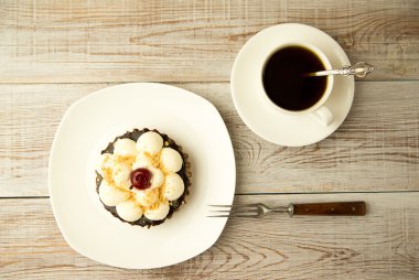 Kek kiraz ve masada bir fincan