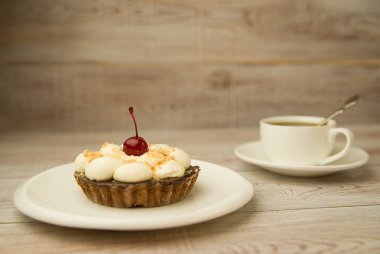 Kek kiraz ve masada bir fincan