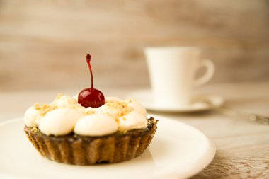 Kek kiraz ve masada bir fincan