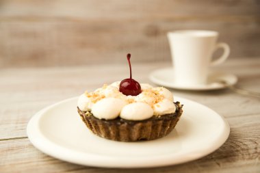 Kek kiraz ve masada bir fincan