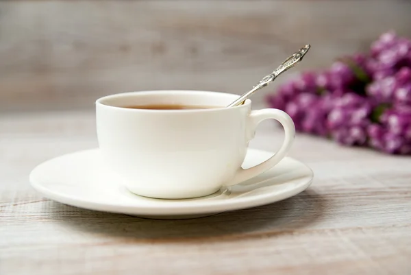 Чашка и блюдце с напитком на столе Стоковое Фото