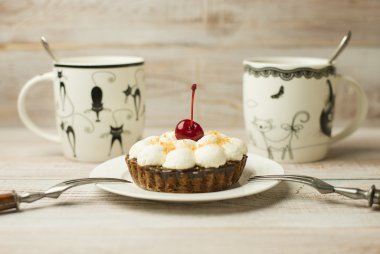 Kek kiraz ve masada bir fincan